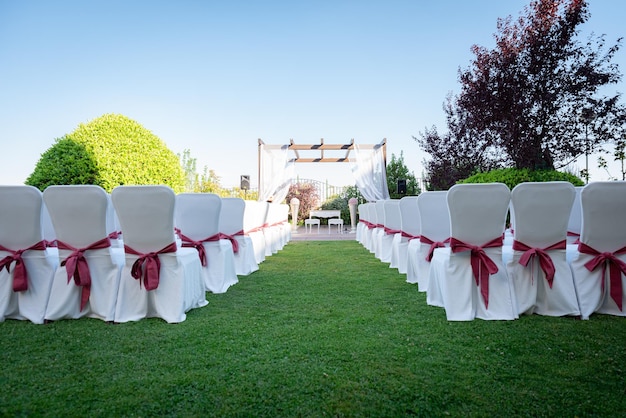 Stühle einer schön verzierten Hochzeit auf grünem Gras