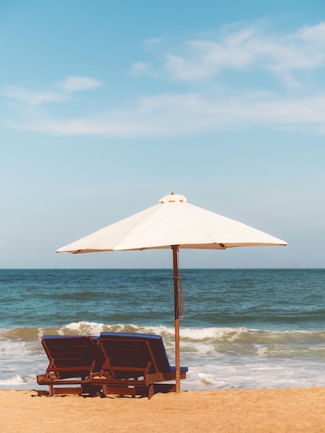 Stühle mit Sonnenschirm am Strand