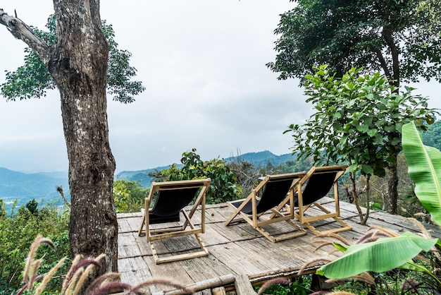 Foto stuhl auf balkon mit berghügel und nebligem hintergrund