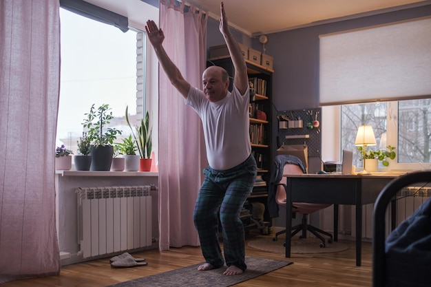 Stuhlhaltung. Kaukasischer Senior, der zu Hause Yoga macht. Pilates, Workout, Bewegungstherapie, Flexibilität, Sport, Balance, Seelenfrieden, mentale Gesundheit