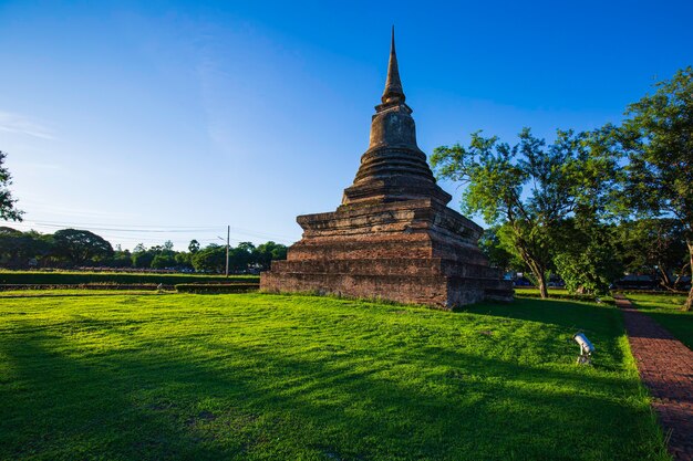 Stupa no Templo Wat Mahathat no Parque Histórico em Sukhothai, céu azul e parque verde