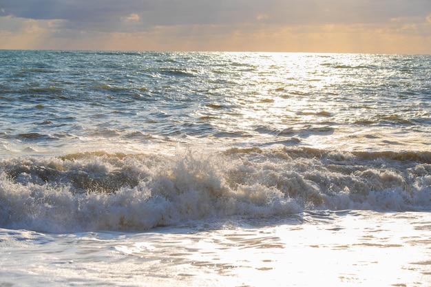 Sturm auf dem Meer in den Strahlen des Sonnenuntergangs große Wellen, sprühen.