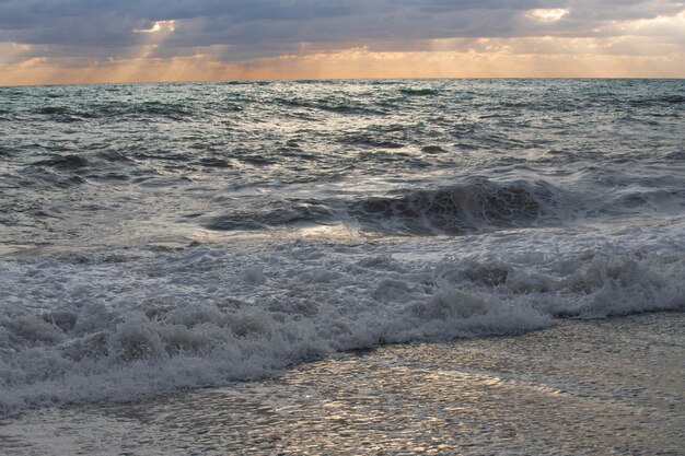 Sturm auf dem Meer in den Strahlen des Sonnenuntergangs große Wellen, sprühen.