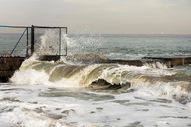 Sturm auf See. Wellen brechen auf dem Pier.