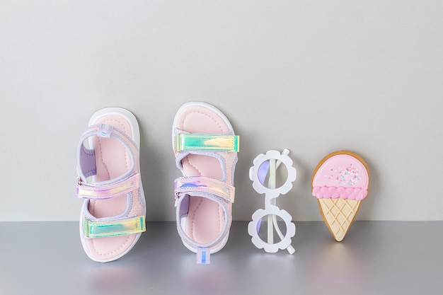 Foto stylische holografische sandalen für kinder auf grauem hintergrund glänzende sommermodeschuhe