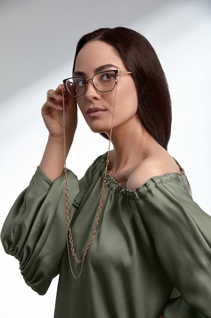 Stylische junge Brünette in grünem Kleid und Brille Magazin-Cover Modebranche erfolgreich