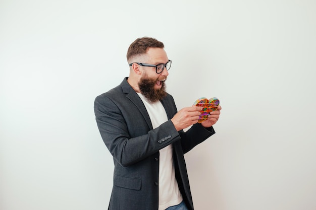 Stylischer fröhlicher junger Hipster-Typ mit Bart spielt mit einem beliebten Spielzeug Pop it Anti-Stress-Sensor-Fidget-Push-Pop-Spielzeug