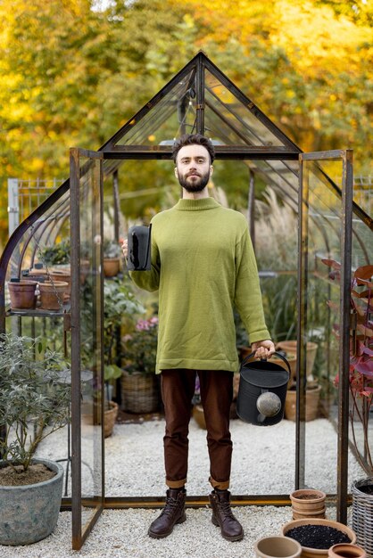 Stylischer Typ mit Gießkanne im Garten