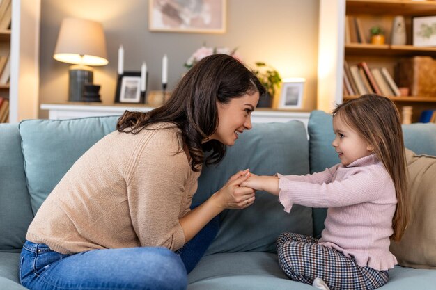 Foto en su casa, una madre y su hija, cariñosamente conocidas como madre y hija, comparten un precioso momento en el sofá. sus sonrisas irradian amor y calidez mientras disfrutan de un tiempo de calidad juntos.