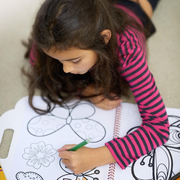 Su creatividad no conoce fronteras Fotografía de una linda niña coloreando sola en casa