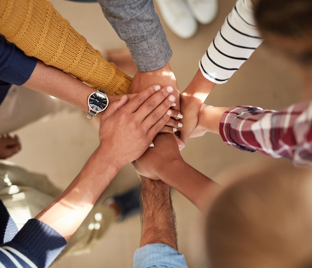 Foto su determinación es fuerte toma en ángulo alto de un grupo de personas uniendo sus manos