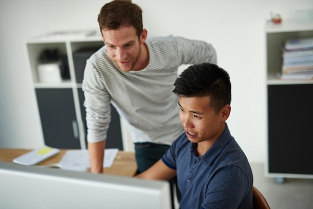 Su éxito se basa en el trabajo en equipo Toma en ángulo alto de dos diseñadores trabajando juntos en un proyecto en una oficina