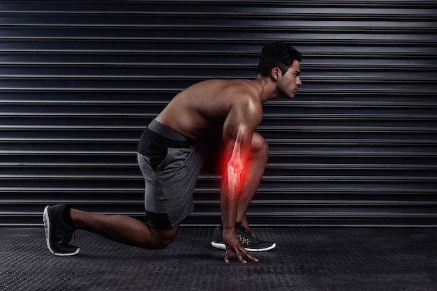 En su marca Toma de cuerpo entero de un joven atlético en su marca antes de correr