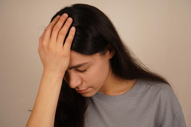 Su postura y expresión reflejan el auto-reconocimiento la foto captura un momento genuino de realización la chica se toca la cabeza con ambas manos señalando el reconocimiento de un error