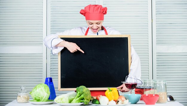 Su producto está aquí. Maestro cocinero presentando algo en la clase de cocina. Pretty Woman señalando con el dedo a la pizarra. Jefe de cocina enseñando en la escuela de cocina. Clase magistral en la escuela culinaria, espacio de copia.