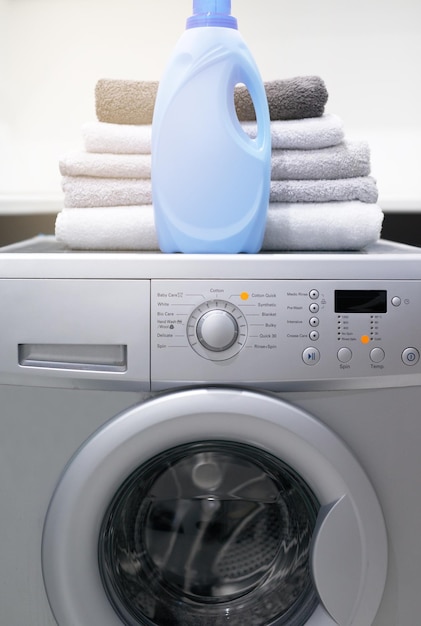 A su ropa le encantará Toma de una lavadora con toallas dobladas y detergente encima