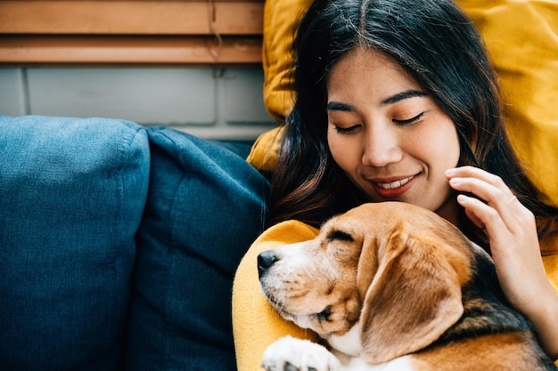 En su sala de estar una mujer y su perro Beagle duermen juntos en el sofá reflejando el vínculo de confianza y amistad que define su relación es un retrato de amor en casa amor de mascotas