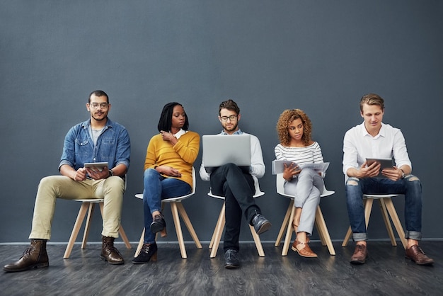 Su temporada de contratación Toma completa de un grupo de empresarios esperando en fila para una entrevista de trabajo