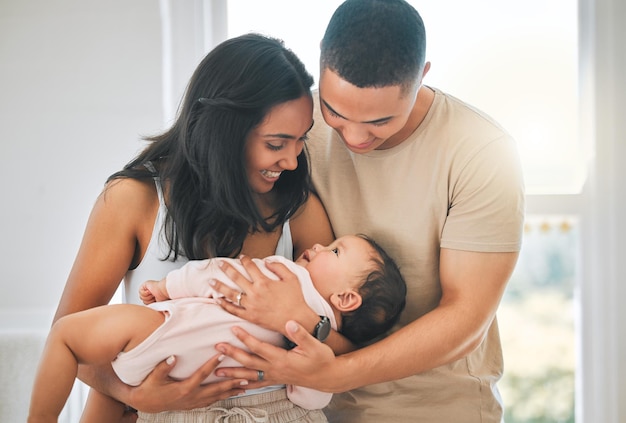 Sua própria pequena família. Foto recortada de um jovem casal afetuoso e seu bebê recém-nascido em casa.