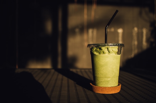 Suave leche de té verde en un vaso de plástico.