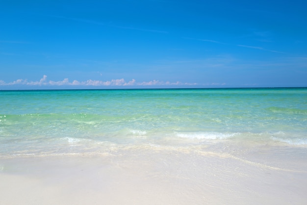 Suave ola azul del océano en la playa de arena limpia hermosa playa con laguna de agua de mar azul y arena blanca ...