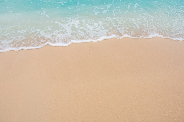 Suave ola de mar en la playa de arena vacía