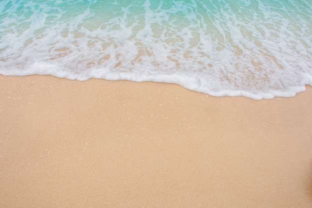 Suave ola de mar en la playa de arena vacía