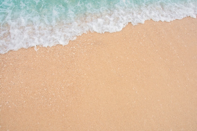 Suave ola de mar en la playa de arena vacía