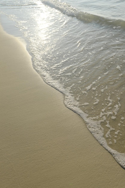 Suave ola del mar en la playa de arena