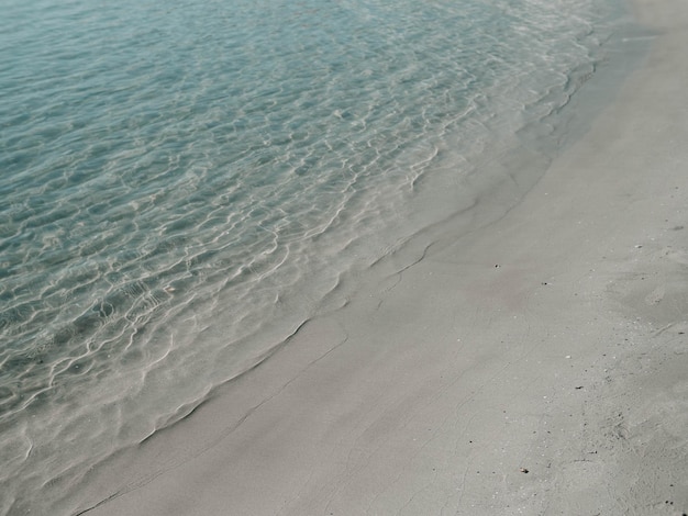 Suave ola oceánica en el fondo de la playa de arena