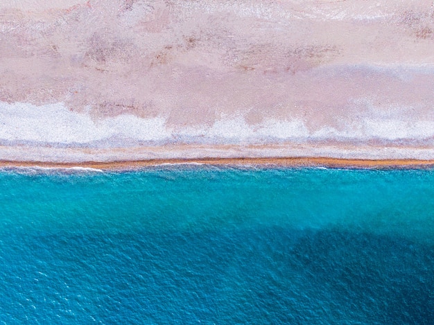 Suave ola de océano azul en la playa de arena