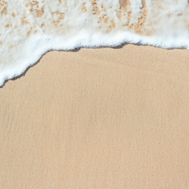 Foto la suave ola del océano en el fondo de la playa de arena