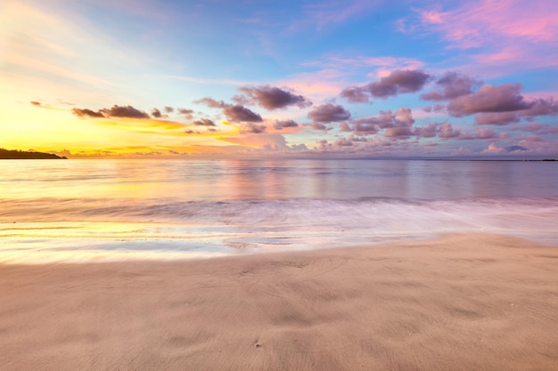 Suave puesta de sol sobre el océano hermosas nubes tropicales y olas de aguas tranquilas