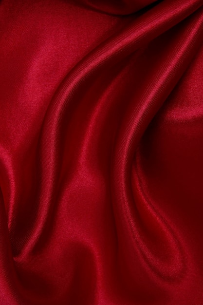 Suave seda roja elegante o textura de tela satinada de lujo como fondo abstracto