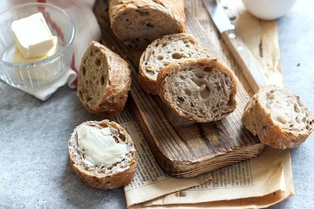 Suaves rebanadas de pan fragante con mantequilla sobre una tabla de madera