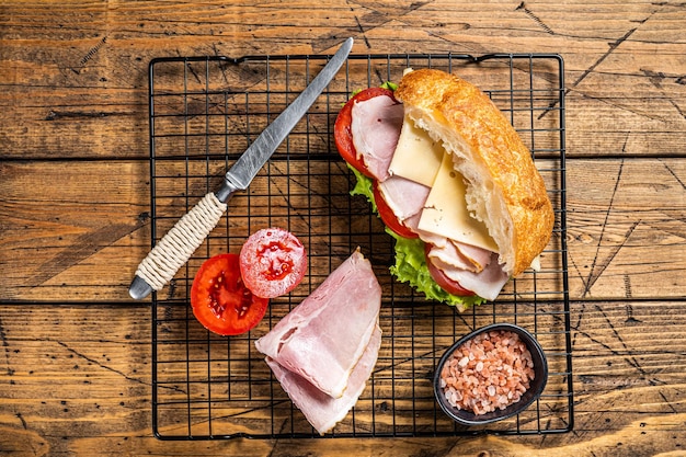 Sub-Sandwich mit Schinken-Käse-Tomate und Kopfsalat Holzhintergrund Ansicht von oben