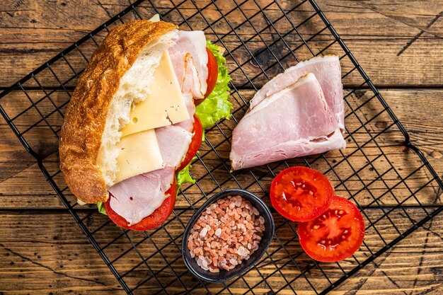 Sub-Sandwich mit Schinken-Käse-Tomate und Kopfsalat Holzhintergrund Ansicht von oben