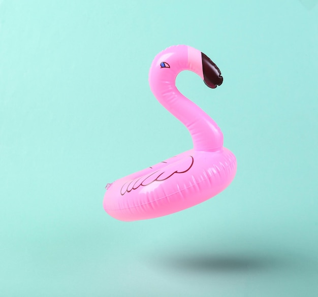Subindo flamingo inflável em um fundo azul Minimalismo foto 3D