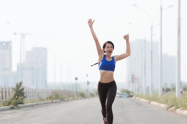 Sucesso da vitória do esporte fitness e conceito de estilo de vida saudável mulher feliz vencendo a corrida