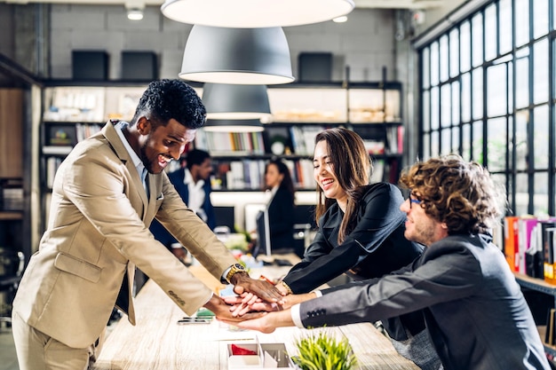 Sucesso dos empresários profissionais do grupo para vencer na celebração do sucesso do projetoNegócios criativos colocando e juntando suas mãos um bom trabalho em equipe no escritório