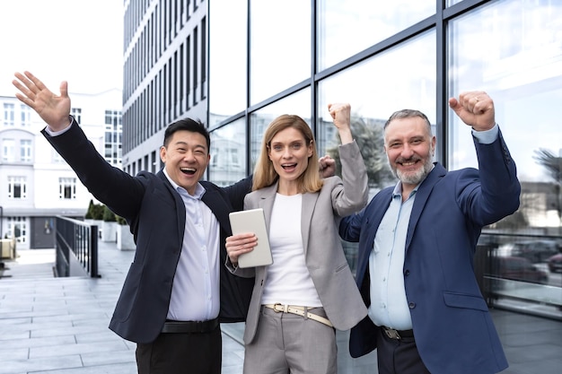 Foto sucesso feliz grupo empresários entusiasmados regozijando-se olhando para a câmera após a conclusão bem sucedida