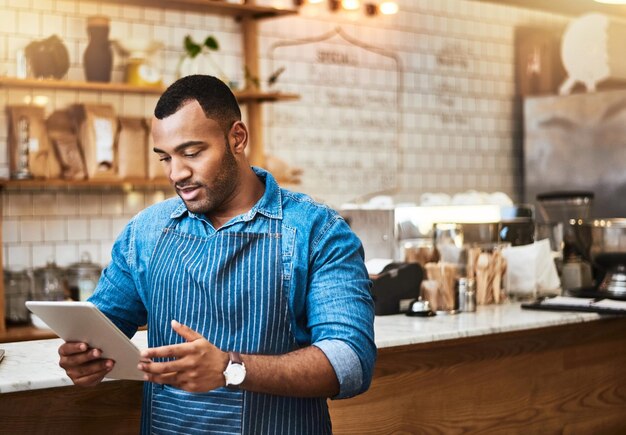 Suche Tablet und Manager mit Mann im Café für Online-Unternehmertum und Startup. Kellnertechnologie und Lebensmittelindustrie mit Kleinunternehmer im Restaurant für Barista-Netzwerk und Café