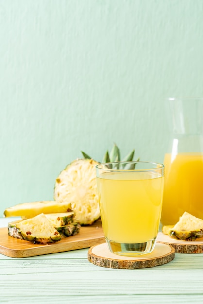 Suco de abacaxi fresco na superfície da madeira