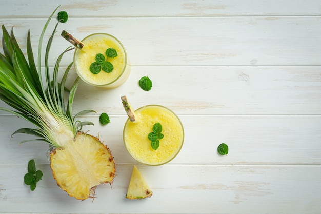 Suco de abacaxi na superfície de madeira branca