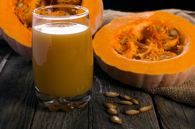 Suco de abóbora na grama na mesa de madeira