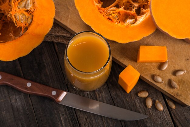 Suco de abóbora na grama na mesa de madeira