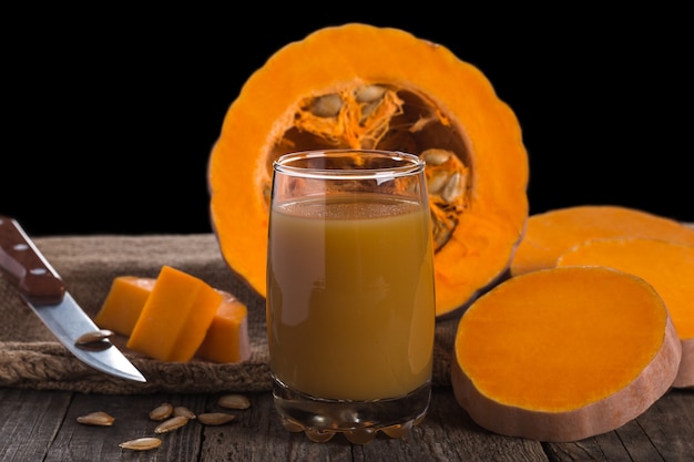 Suco de abóbora na grama na mesa de madeira