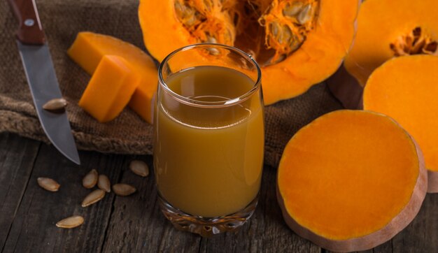 Suco de abóbora na grama na mesa de madeira