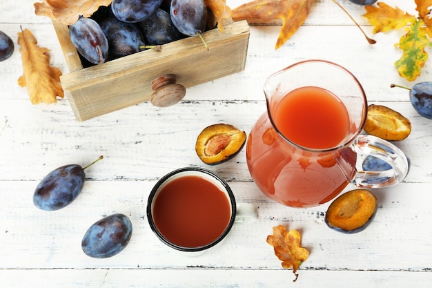 Suco de ameixa em frasco e caneca com frutas frescas