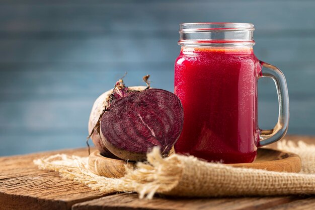 Suco de beterraba vermelha em copo de vidro sobre a mesa de madeira